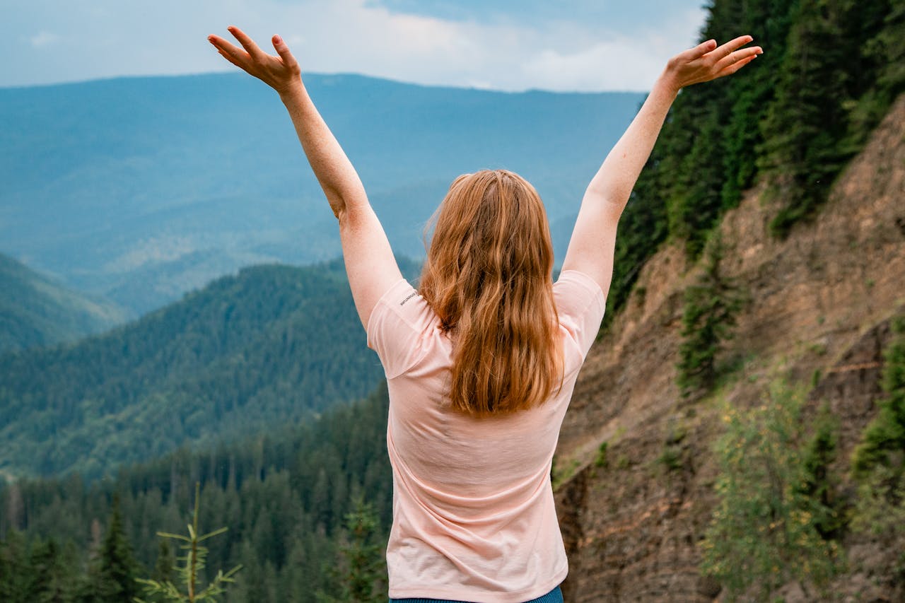 Joyful Woman Embracing Nature on Mountain
